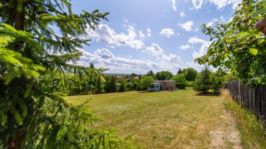 Příjemná venkovská zahrada s rekreačním karavanem a terasou.